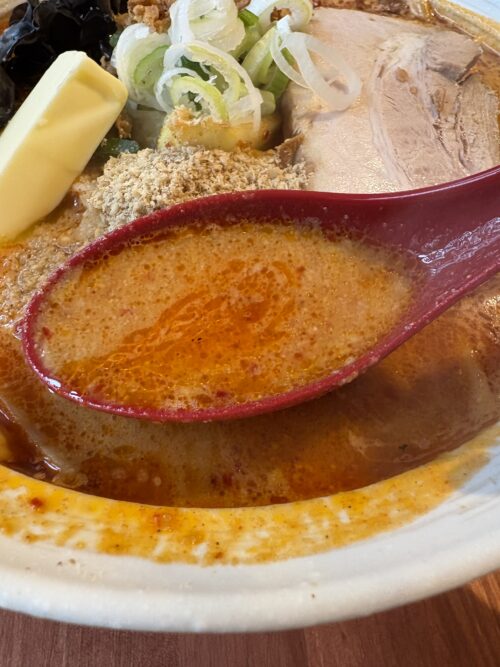 辛味噌ラーメンのスープ。濃厚でコクがあり、辛さがしっかりと感じられる一杯。