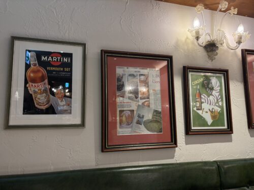 難波イタリアン「サンタアンジェロ」店内の壁飾り。レトロでおしゃれなイタリアンテイストのポスターや絵画。