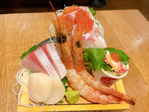 難波の居酒屋ニューツルマルの刺身盛り合わせ。エビ、ホタテ、サーモン、いくらなど6種の新鮮な魚介