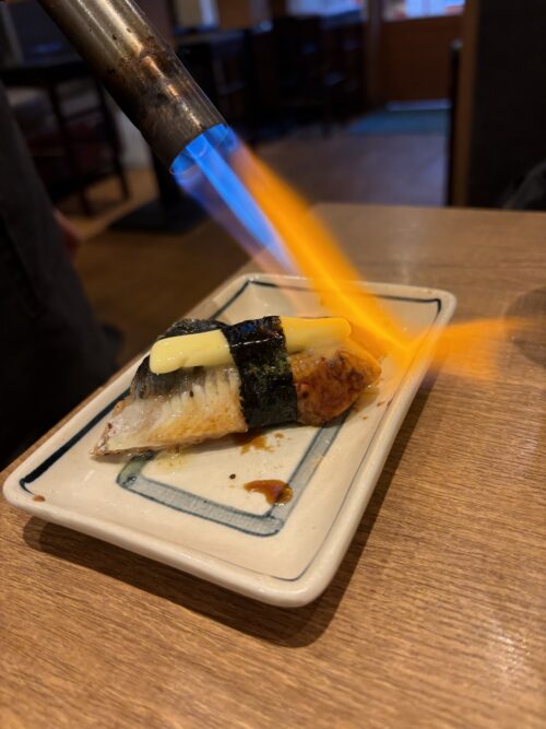 難波の居酒屋ニューツルマルのうなぎバター。バーナーで炙って仕上げる香ばしい一品